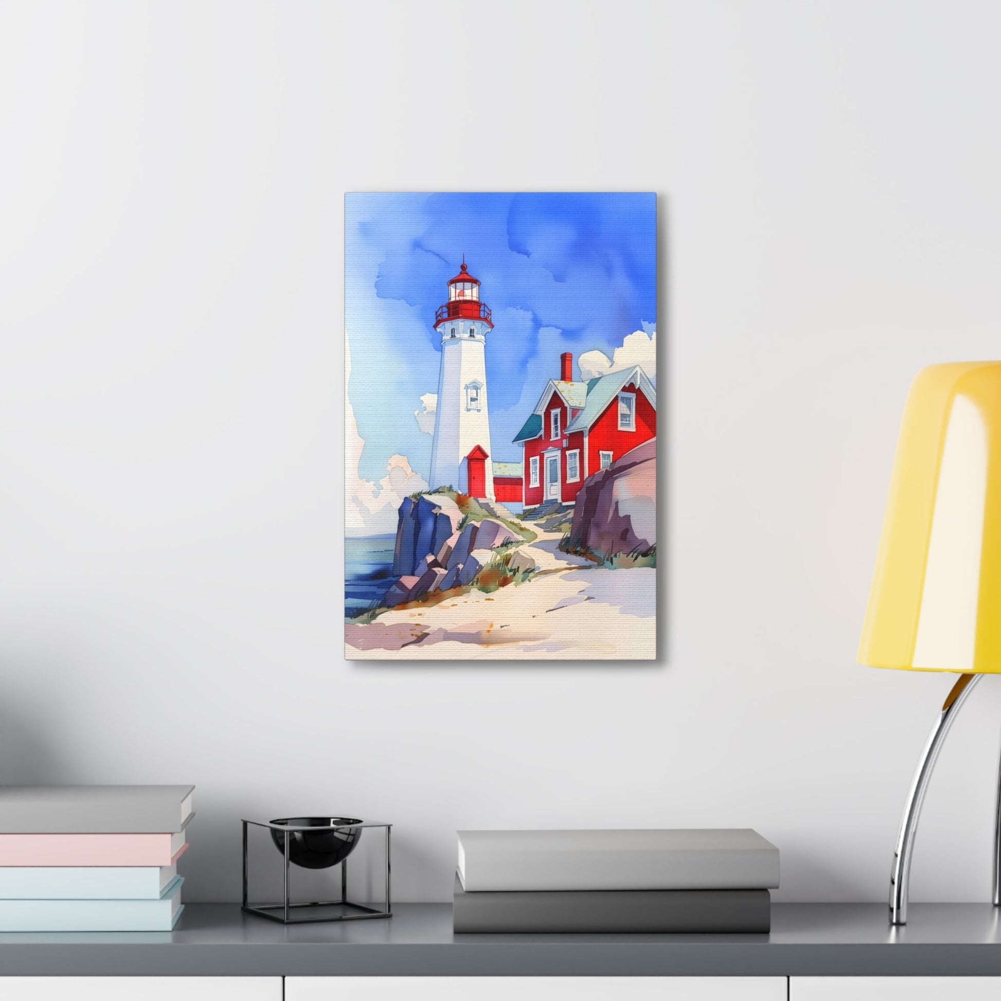 Vertical-oriented wall art: A watercolor-style painting of a lighthouse perched on rocky cliffs overlooking a vast ocean. The sky is painted in shades of blue with wispy white clouds, and the rugged coastline is depicted in intricate detail.