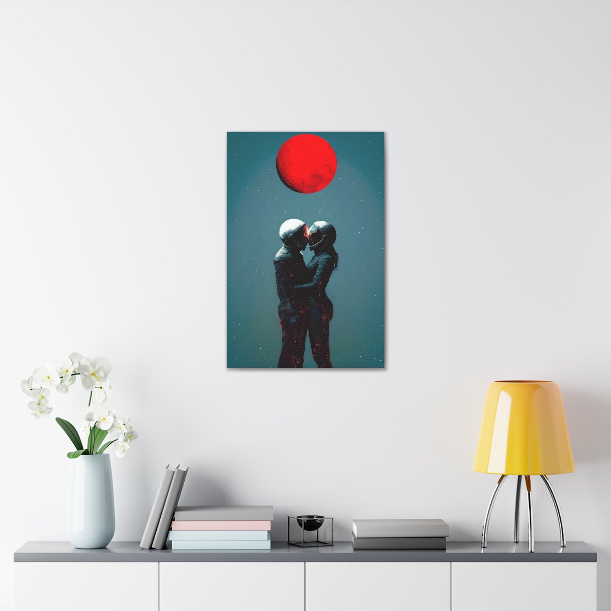 Vertical-oriented wall art: "Galactic Romance IV" depicts two astronauts embracing under a glowing red moon, their helmets gently touching as they share a moment of intimacy in space. The starry background contrasts with the fiery red moon, emphasizing the romantic and cosmic connection between the figures.