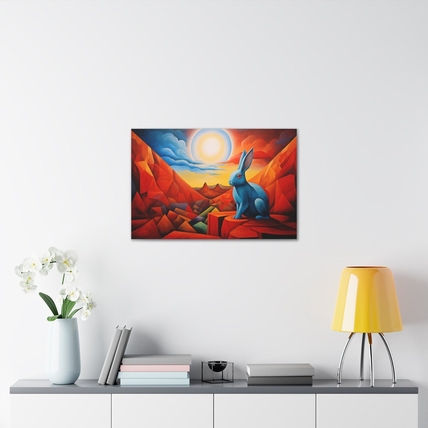 Horizontal-oriented wall art: "Vortic Hare III" features a vibrant blue rabbit sitting calmly on angular red rocks in a surreal, geometric landscape with a glowing sun in the background. The bold contrast of vivid blue, red, and orange tones evokes a dynamic fusion of Vorticism, Cubism, and Surrealism.