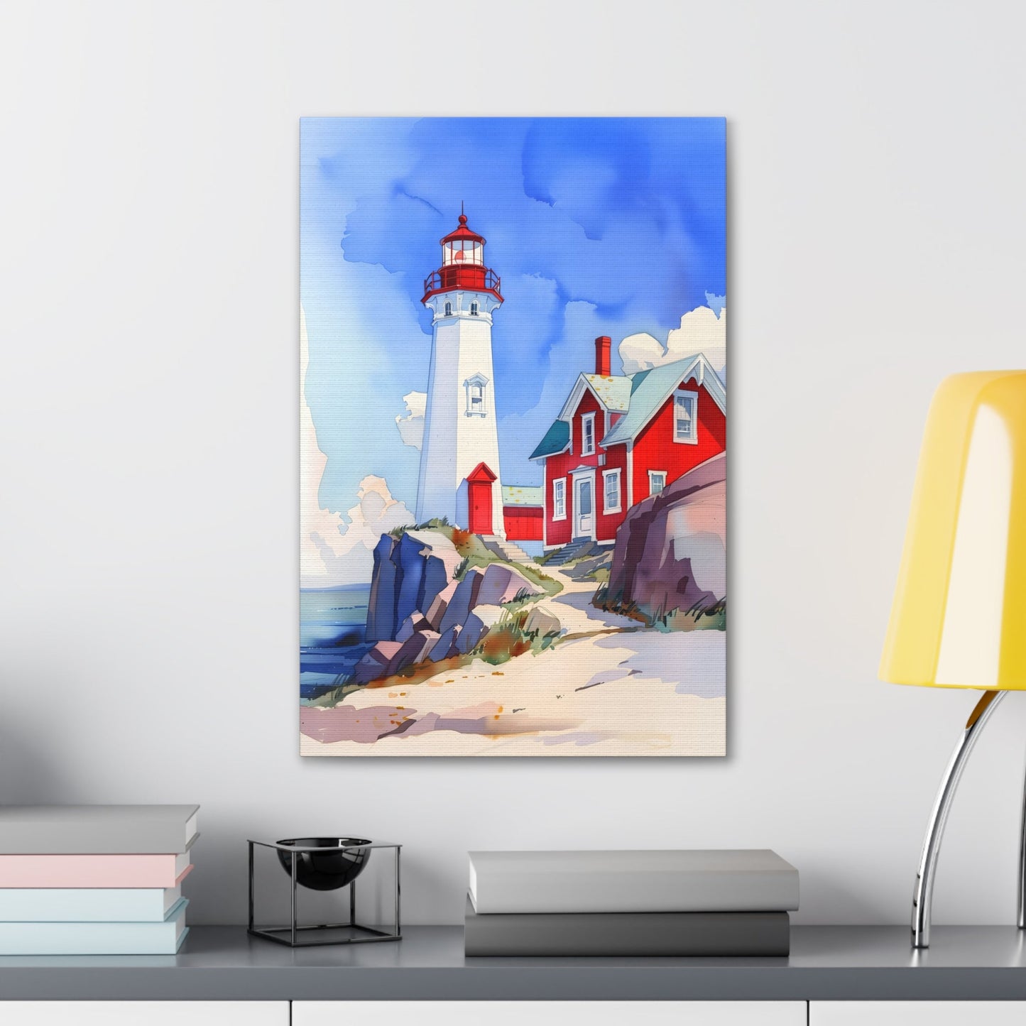 Vertical-oriented wall art: A watercolor-style painting of a lighthouse perched on rocky cliffs overlooking a vast ocean. The sky is painted in shades of blue with wispy white clouds, and the rugged coastline is depicted in intricate detail.